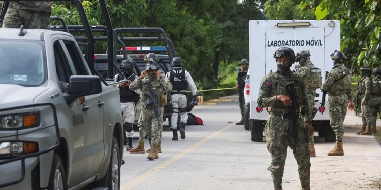 Mexican armed forces stand guard near a crime scene where several local police officers were shot dead by gunmen, in Coyuca de Benitez, Mexico October 23, 2023. REUTERS/Javier Verdin