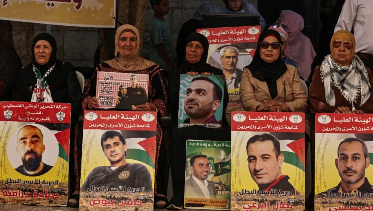 People lift placards bearing portraits of Palestinians currently detained by Israel during a protest in solidarity with them and with the residents of the Gaza Strip, in Ramallah city in the occupied West Bank on July 30, 2024, amid the ongoing conflict in Gaza between Israel and the Palestinian militant Hamas movement. | Photo: AFP